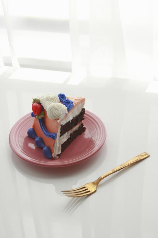 Slice of Black Widow Cake on a pink plate with fork